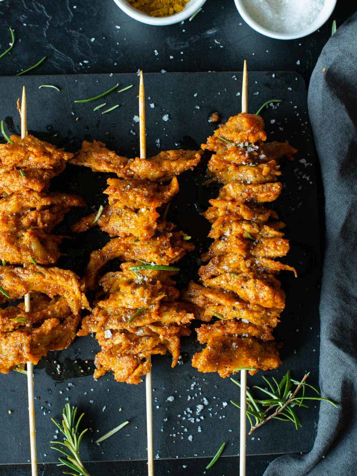 Das Bild zeigt die veganen Seitan-Spiesse, serviert auf einer Servierplatte.