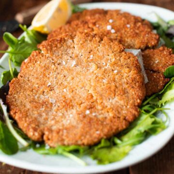 vegan oat schnitzels onto a serving dish.