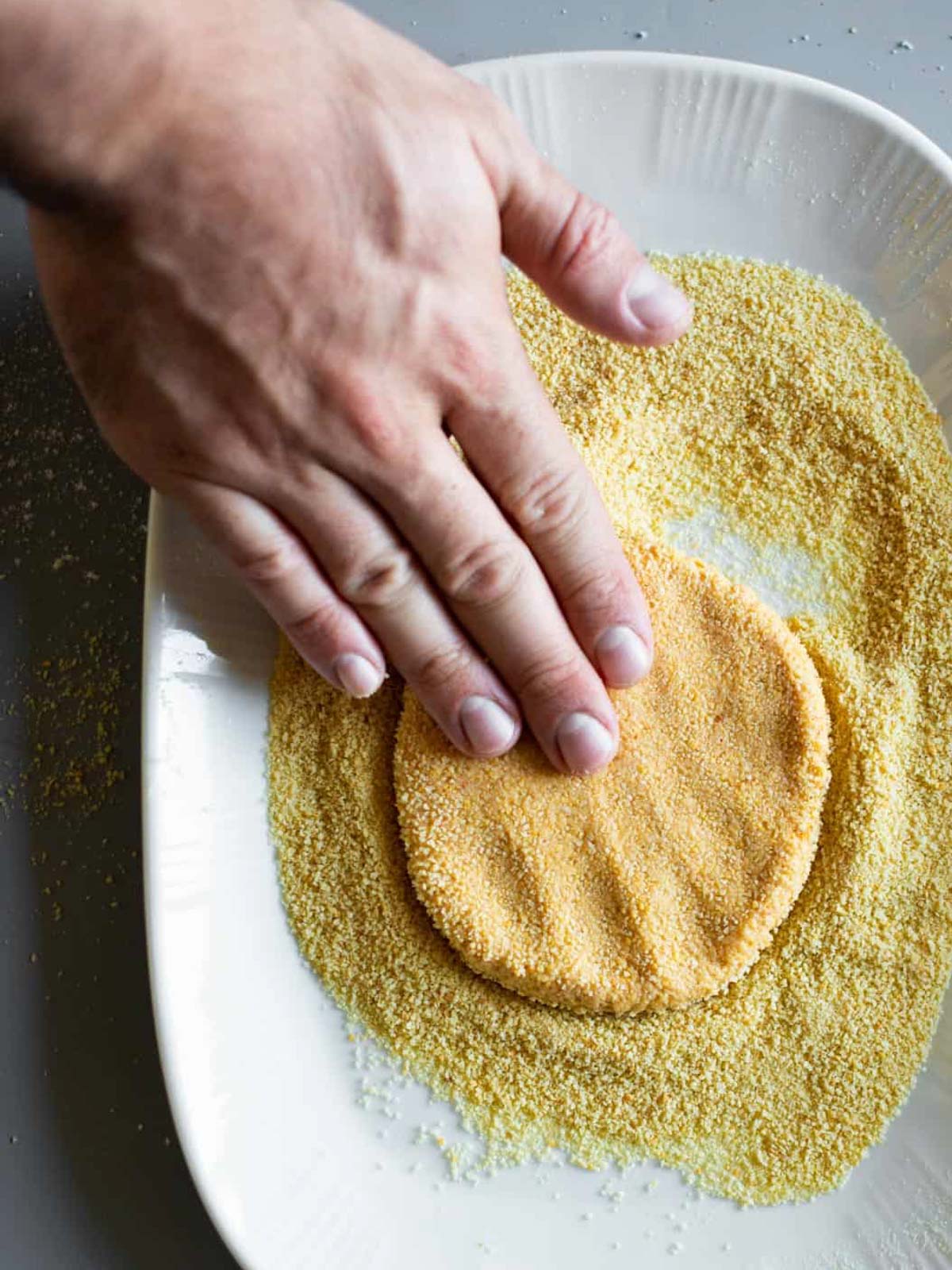 Das Bild zeigt wie man einen veganen Hafer-Schnitzel formt.