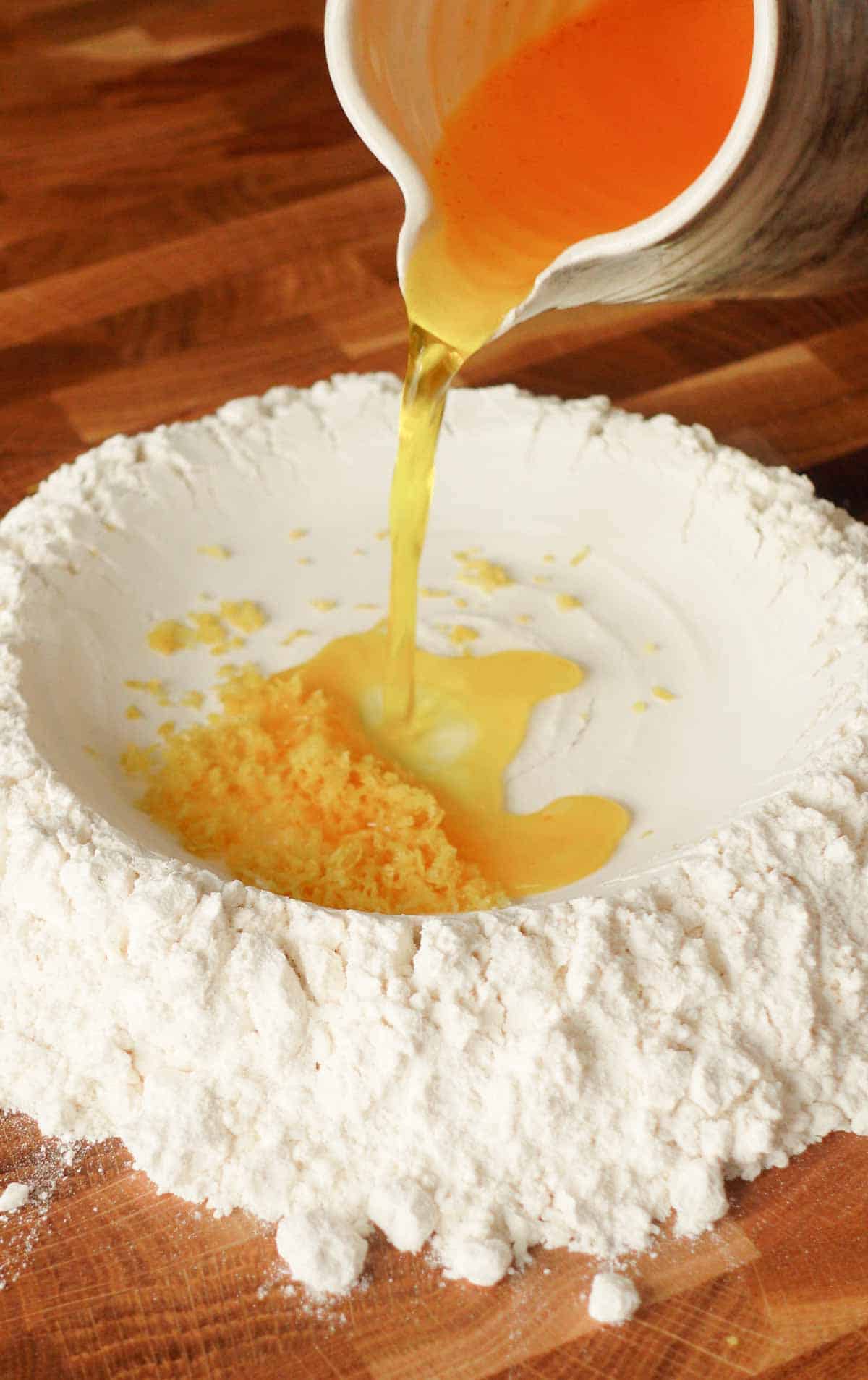 image: making ravioli dough by adding moist ingredients to the dry ones