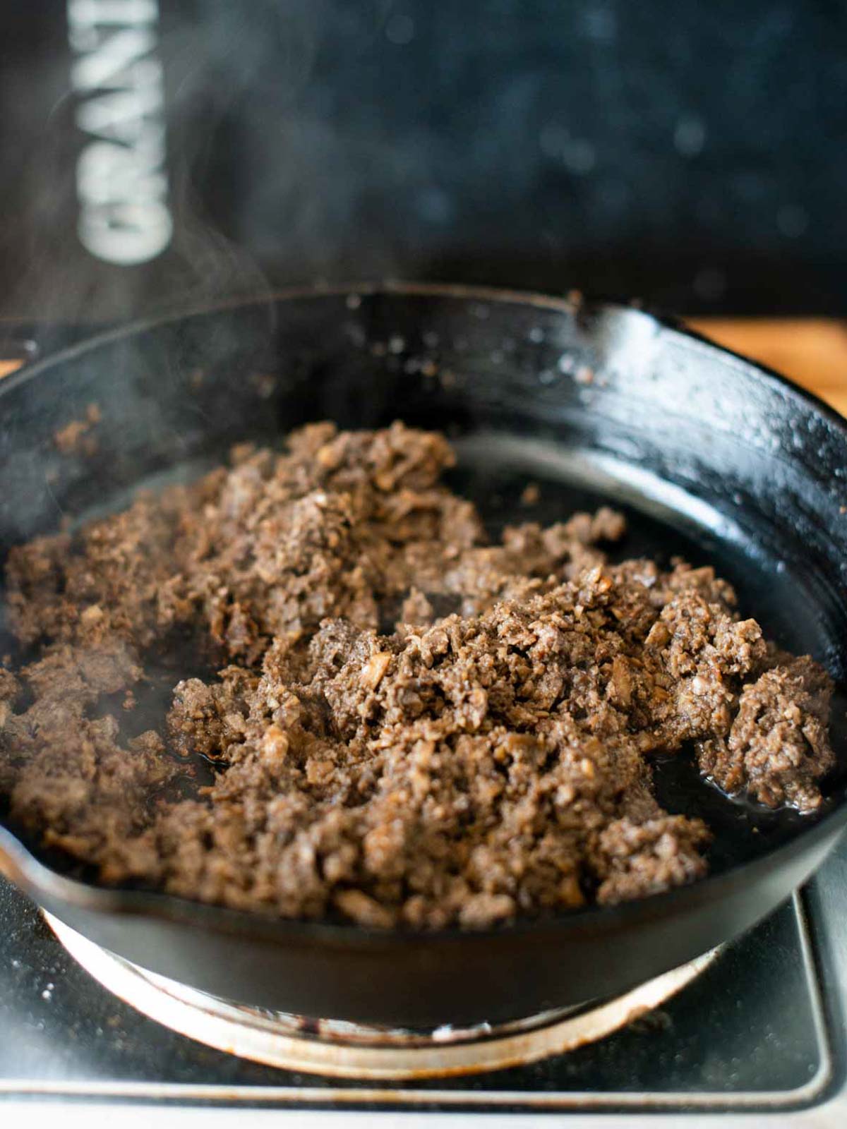 Das Foto zeigt die gehackten Pilze, die in der Pfanne goldbraun gebraten wurden, bevor die Tomaten hinzugefügt werden.