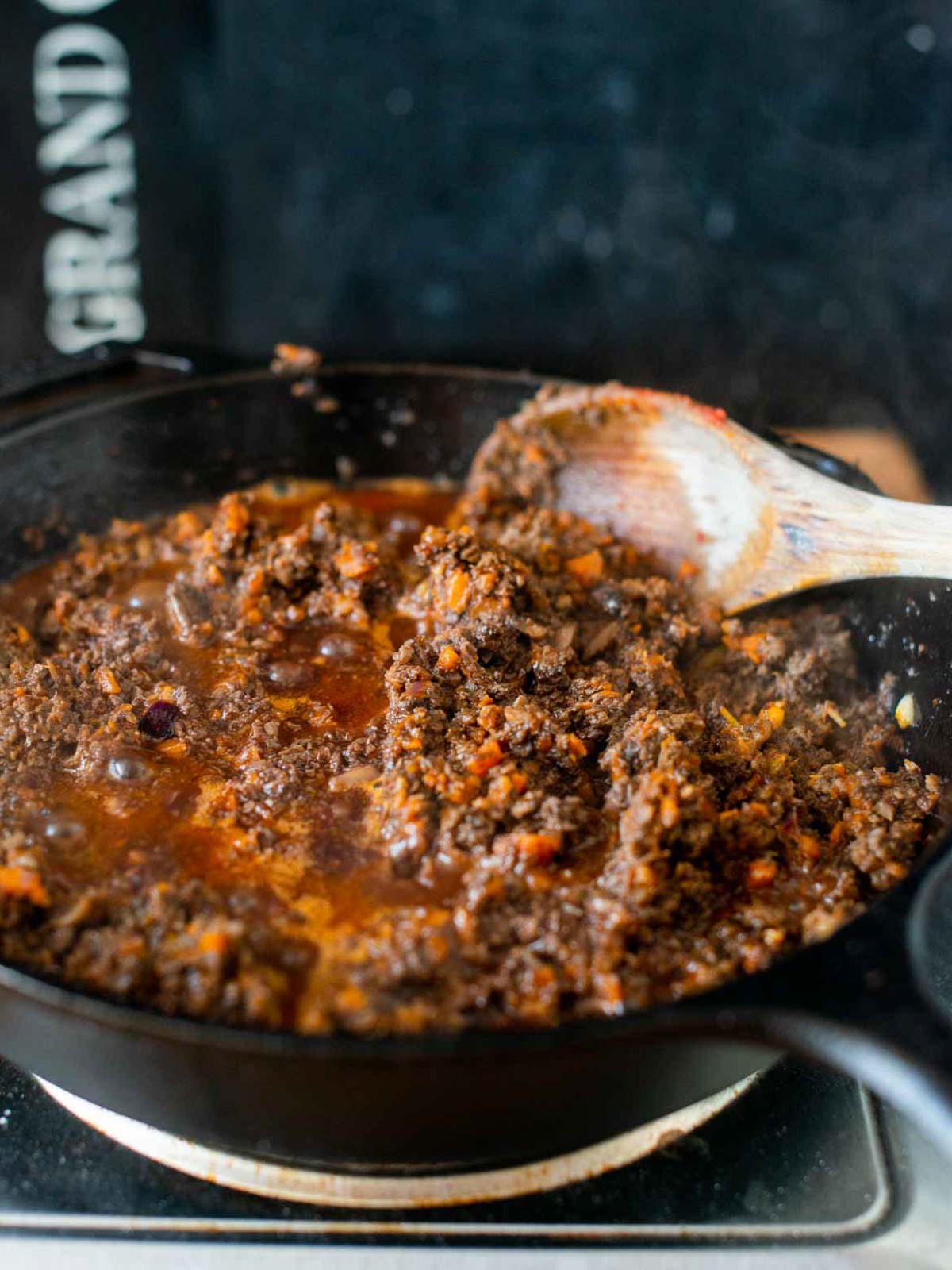 Das Foto zeigt die gehackten Pilze, die in der Pfanne goldbraun gebraten wurden, nach der Zugabe der Dosen-Tomaten.